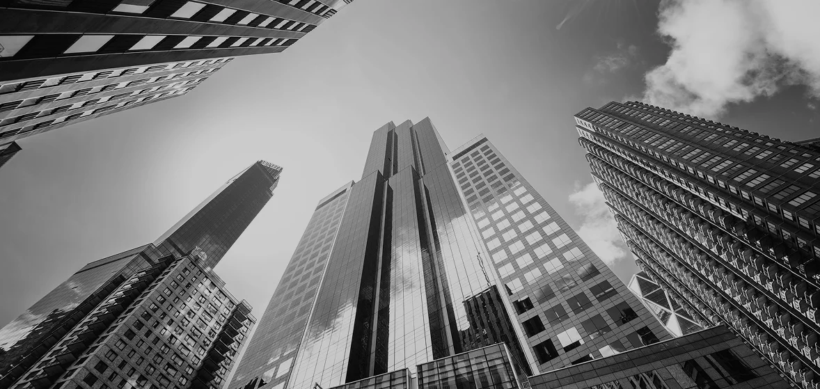 Black-and-white view of modern skyscrapers shot from below against the sky - Hair Restoration in New York, NY